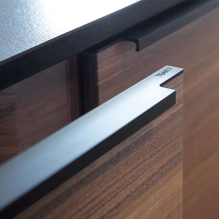 Nussbaumküche black line mit Griffprofil Edelstahl Finish schwarz und TEAM 7 Gravierung, Detailansicht
