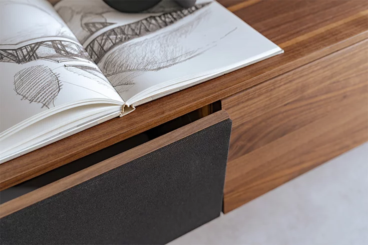 Detailed view of loudspeaker flap in solid walnut covered with acoustic fabric