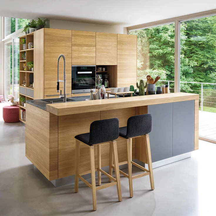 linee solid wood kitchen in oak with coloured glass fronts medium grey matt, worktop in natural stone and bar element with ark bar stools