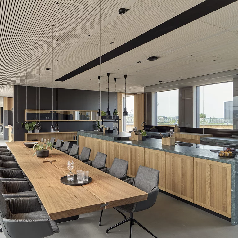 Show kitchen with echt.zeit kitchen and echt.zeit table made of solid oak and lui léger swivel chairs with leather and fabric upholstery