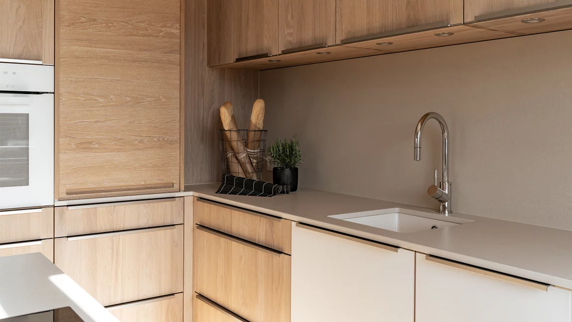 Solid linee kitchen in detail with handle profiles, lighting and ceramic worktop