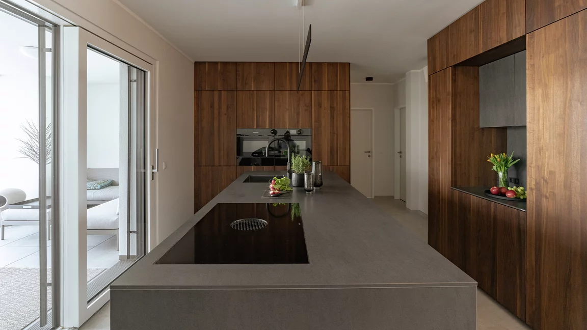 Moderne Kücheninsel und raumhohe Massivholz Küchenschränke für viel Stauraum Moderne black line Kücheninsel und raumhohe Massivholz Küchenschränke aus Nussbaum für viel Stauraum