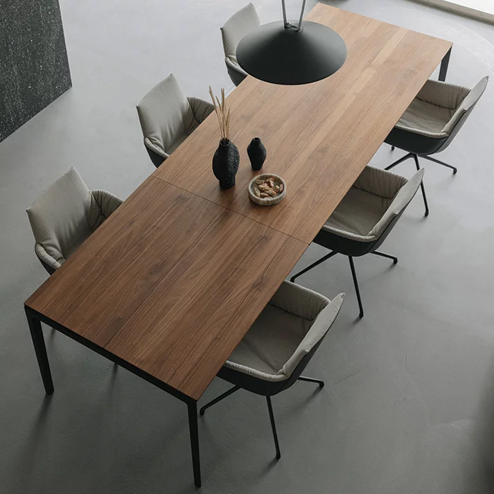 ausziehbarer Esstisch tak aus Massivholz Nussbaum mit Metallgestell in schwarz matt und der lui léger Stuhlgruppe