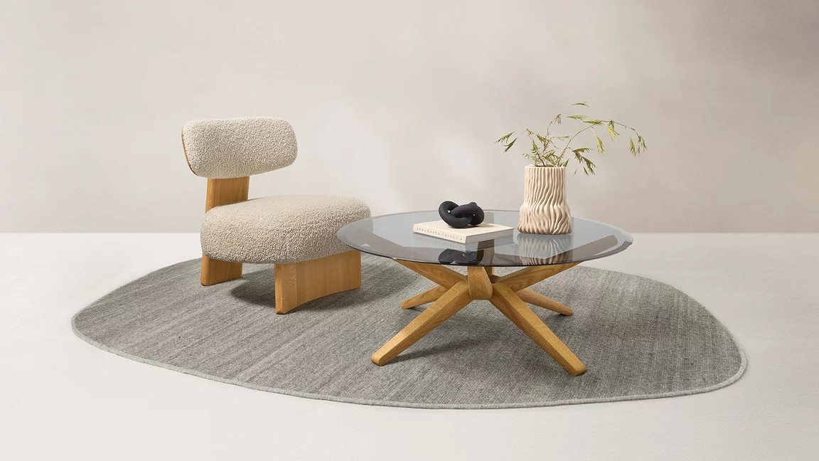 Couchtisch stern mit Rauchglasplatte neben elliot Lounge Chair mit Nimbus nuvola Bezug in Eiche