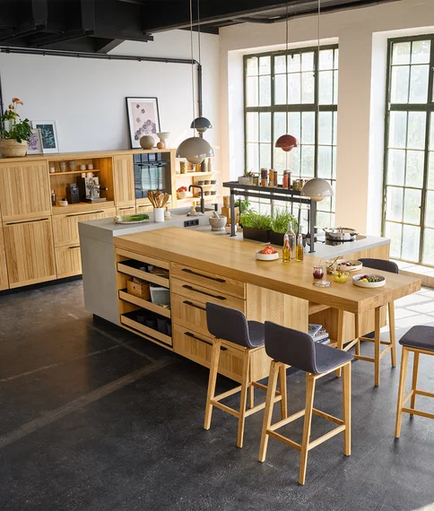 echt.zeit solid wood kitchen in oak with ceramic worktop and integrated dining area with ark bar stools