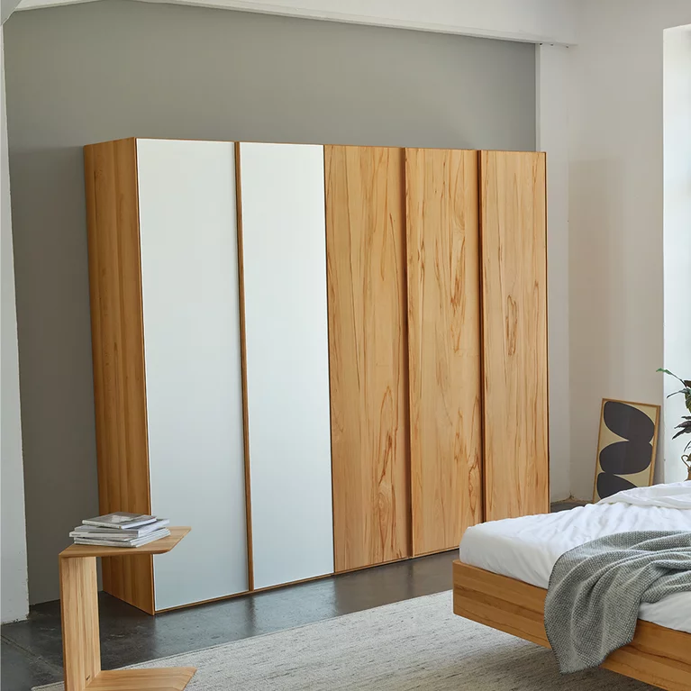 soft hinge door wardrobe in beech heartwood with coloured glass fronts together with the times bed and the clip side table