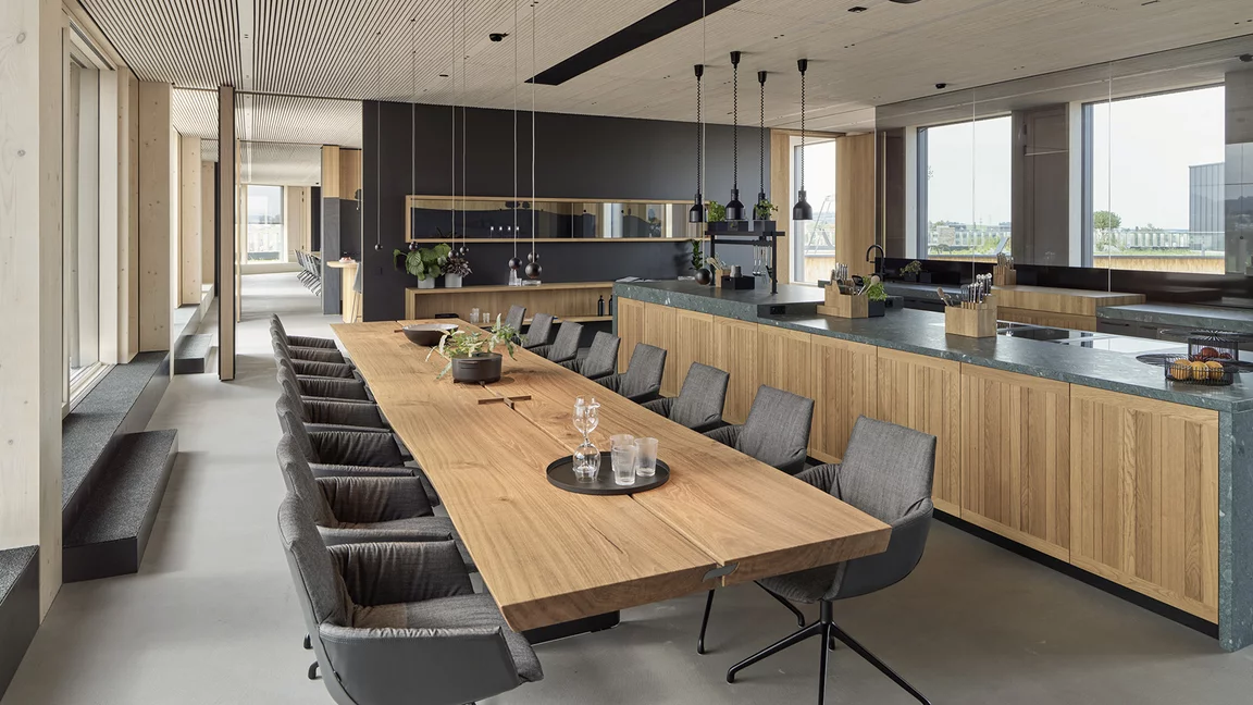 Show kitchen with echt.zeit kitchen and echt.zeit table made of solid oak and lui léger swivel chairs with leather and fabric upholstery