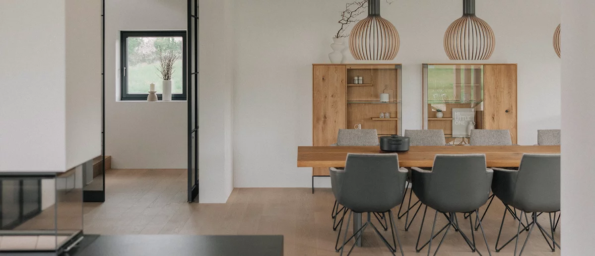 Modern dining room with gand lui chairs at echt.zeit table in front of two filigno highboards in natural oak oil