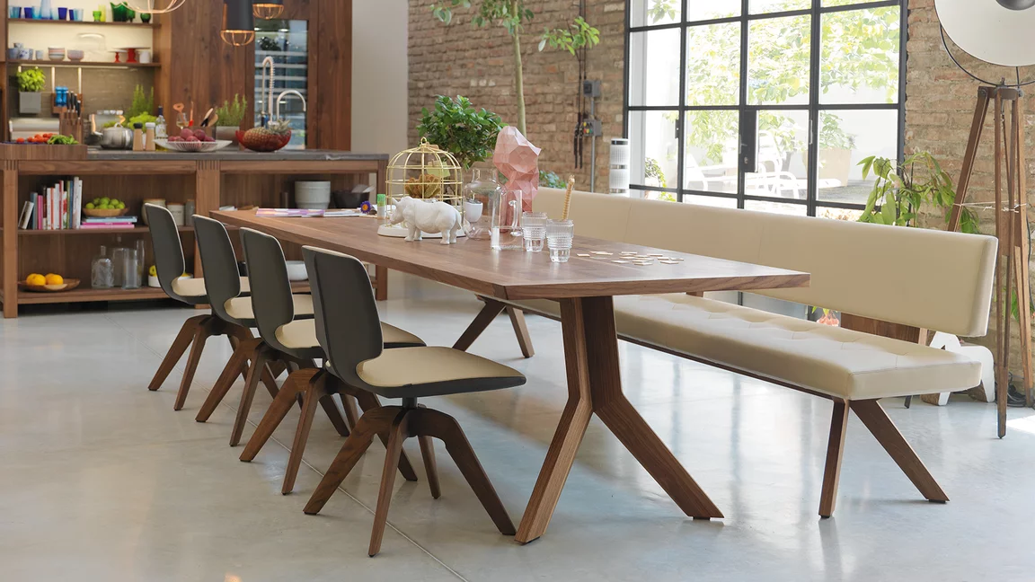 modern yps extendable dining table in solid walnut with the aye swivel base chair and the yps upholstered bench with backrest
