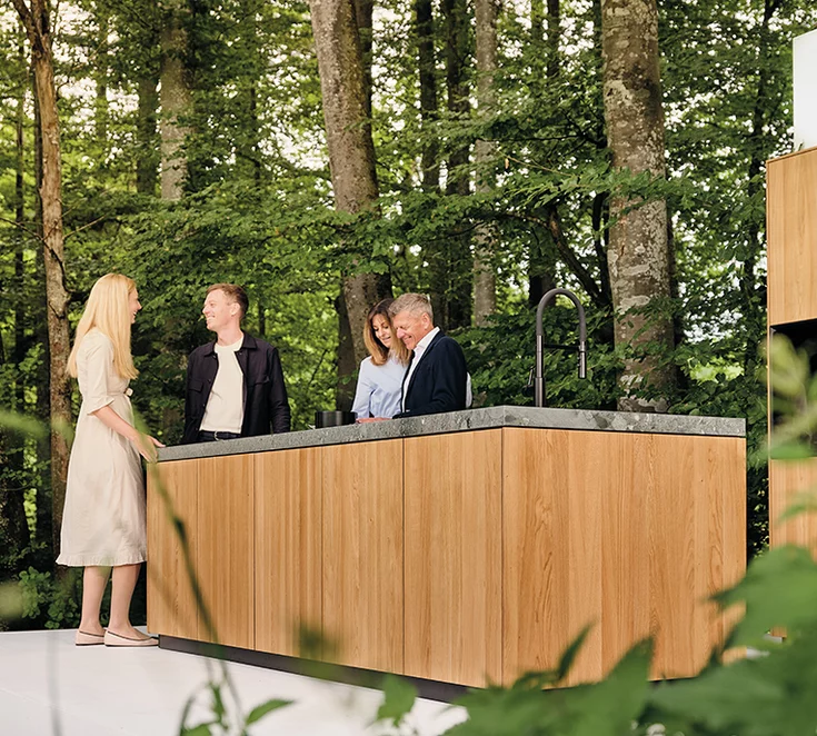 Familie Emprechtinger umringt von Bäumen in unserer TEAM 7 filigno Küche auf der Waldbühne