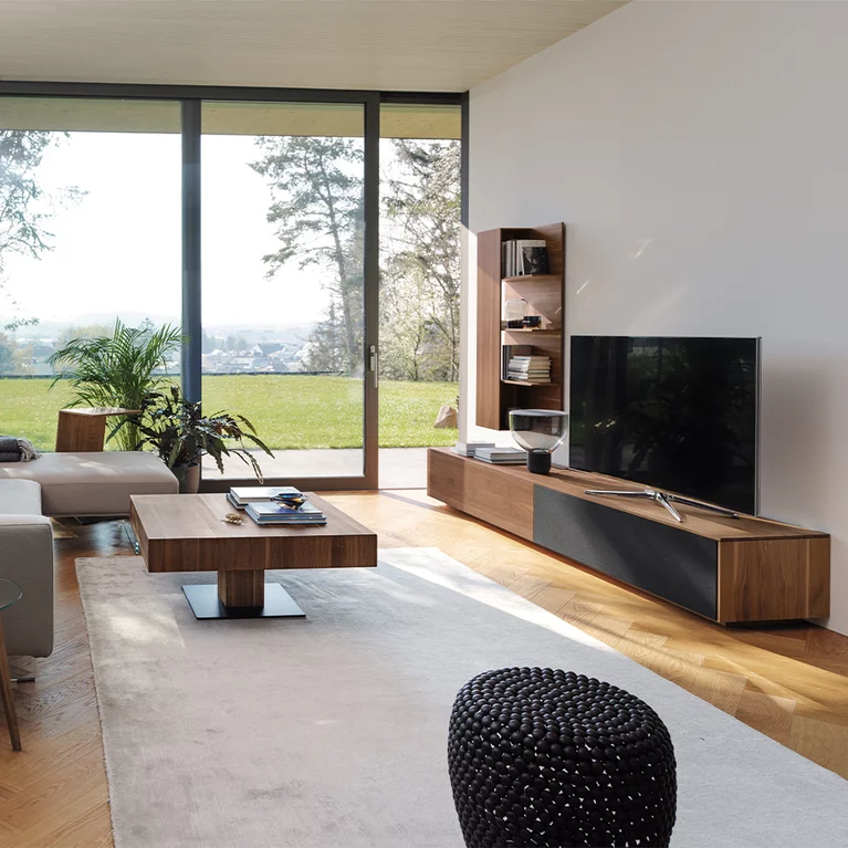 modern living room in dark wood with filigno wall unit, boarde and lift coffee table