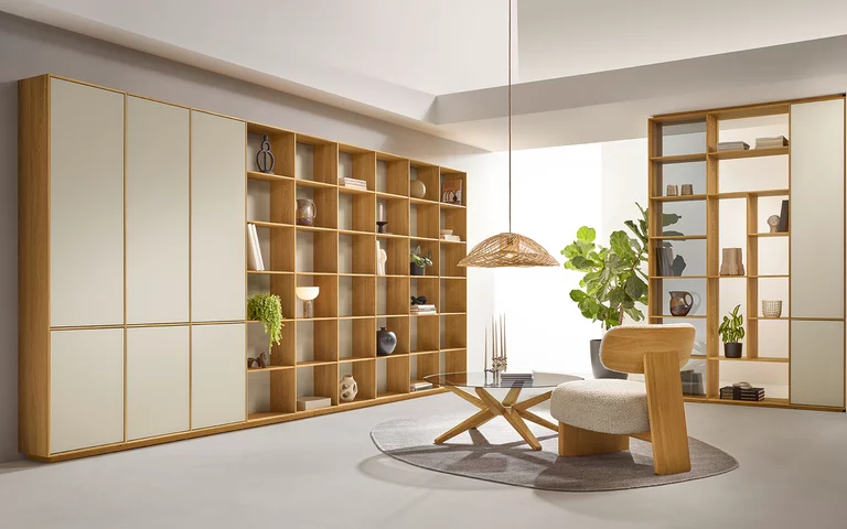 Modernes Regal und Raumteiler filigno mit Farbglastüren greige hinter stern Couchtisch mit Rauchglasplatte und elliot Lounge Chair mit Nimbus nuvola Bezug in Massiver Eiche Naturöl