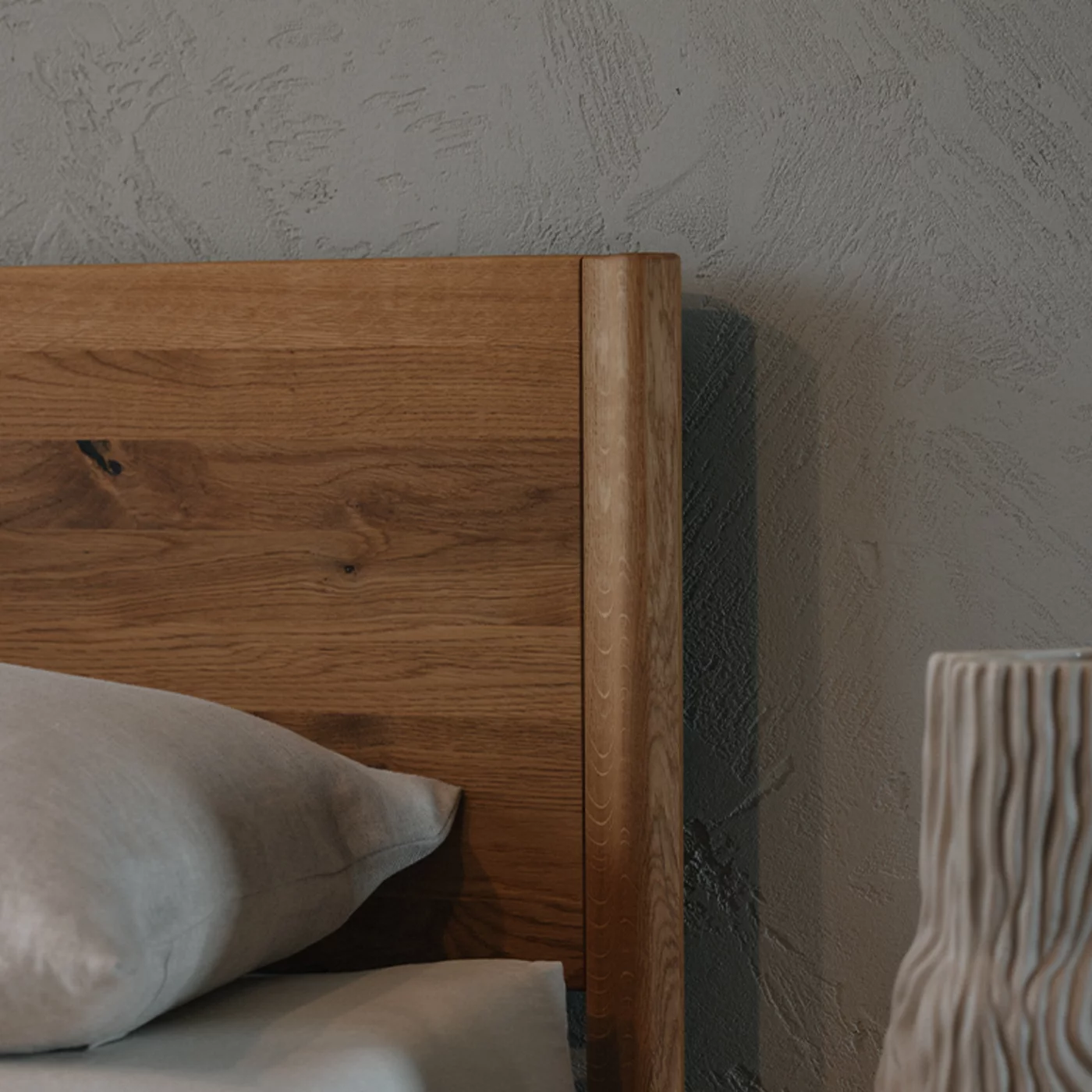 detailed view of the wooden headboard in solid wild oak of the times bed