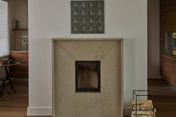 Modern fireplace made of honed travertine in the background Kitchen made of solid walnut wood