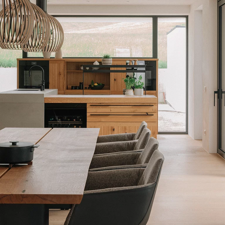 echt.zeit table with grand lui chairs in leather and fabric cover in front of echt.zeit kitchen