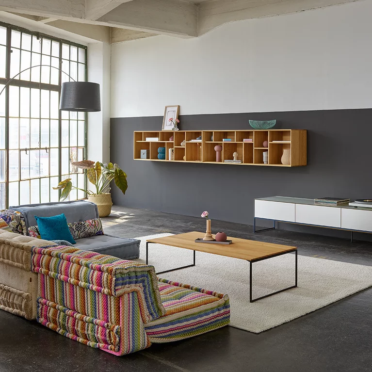 filigno Couchtisch und Wohnwand kombiniert mit dem graphic Gestaltungselement aus Eiche Naturöl und Farbglas