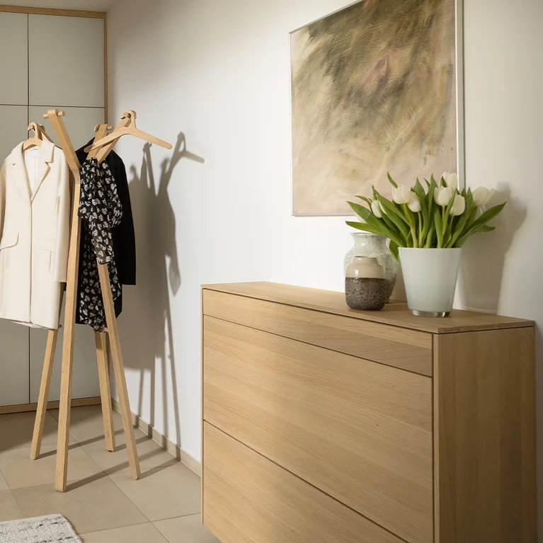elegant wooden floorboards filigno matching the wardrobe cabinets with coloured glass fronts in white and the coat rack hood in solid oak white oil