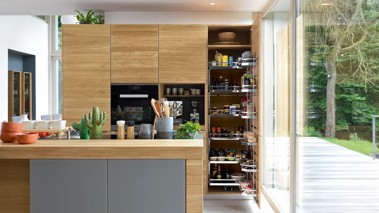 modern kitchen linee in solid oak with coloured glass fronts medium grey matt and tall unit with practical interior drawers