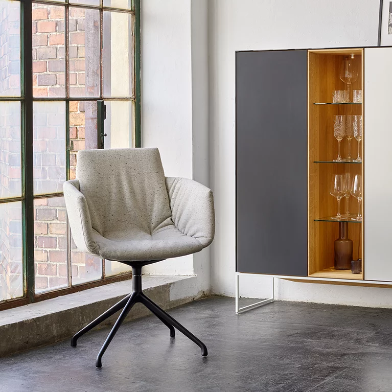 moderner Polsterstuhl grand lui mit Drehgestell in schwarz matt und dem cubus pure Highboard