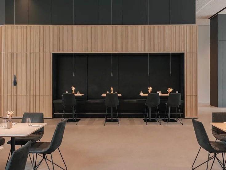 Elegante Restaurantsitzplätze mit lui Barstühlen und Massivholztischen in Eiche Naturöl im Restauran in der TEAM 7 Welt