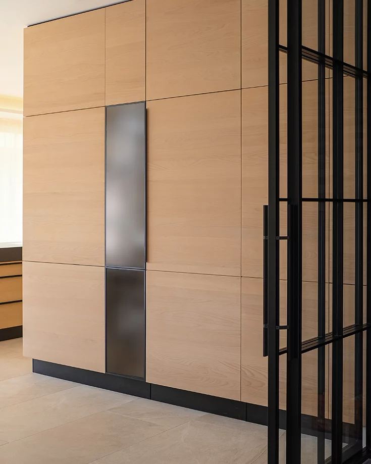 Custom-made kitchen unit with integrated display cabinet and concealed door to the pantry