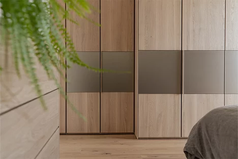 Solid wood hinged door wardrobe valore in oak white oil with integrated wooden handle strips and colored glass elements in bronze