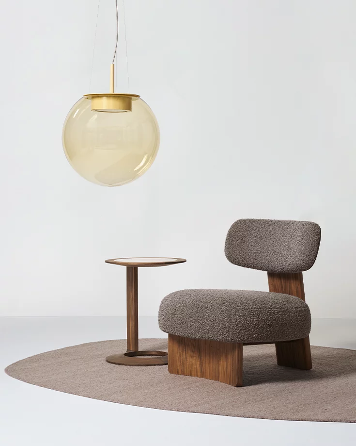 elliot Lounge Chair nebenan der elegante loup Beistelltisch aus Nussbaum mit Farbglas