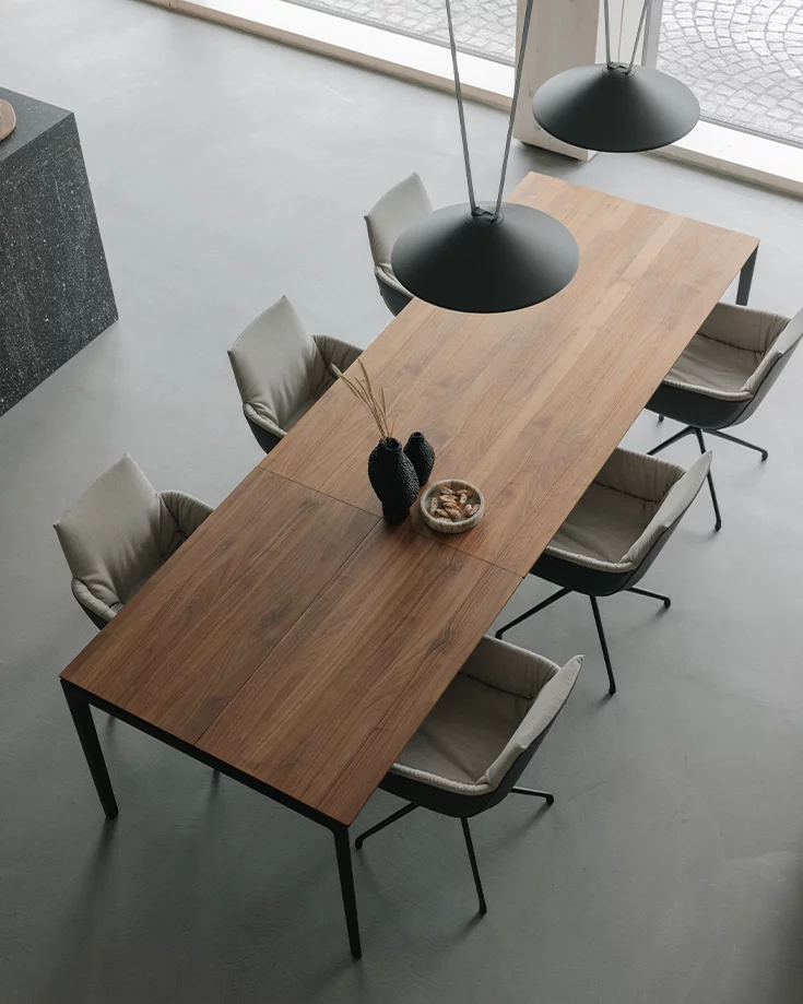 lui léger upholstered dining chair with swivel base in matt black and tak extendable table in walnut