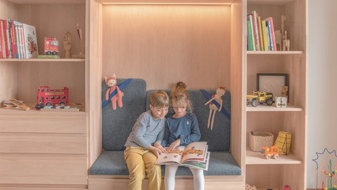 Kleiderschrank kids in Erle Weißöl mit großen Laden und gepolsterten Sitznische beleuchtet