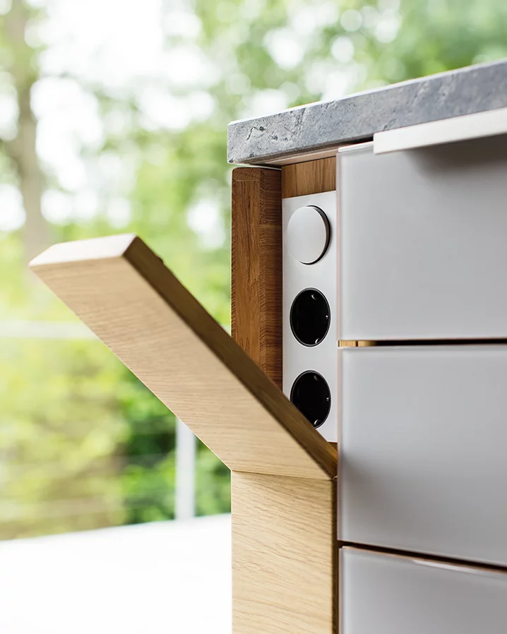 natural wood kitchen linee in oak with integrated sockets with coloured glass fronts in medium grey matt, detailed view