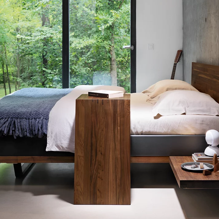 Massivholzbett in Nussbaum mit Holzkopfhaupt, Lederbettseiten, Nachttischholzkonsole und sidekick Beistelltisch