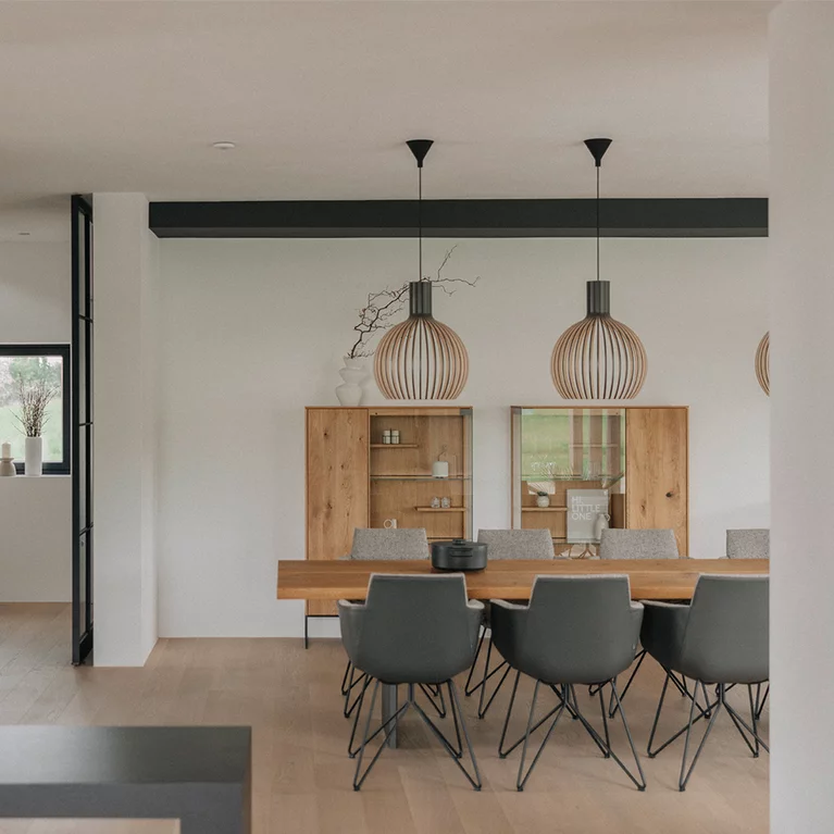 Modern dining room with gand lui chairs at echt.zeit table in front of two filigno cabinets in natural oak oil