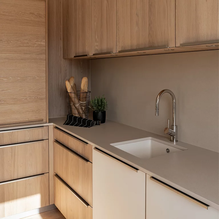 Solid linee kitchen in detail with handle profiles, lighting and ceramic worktop
