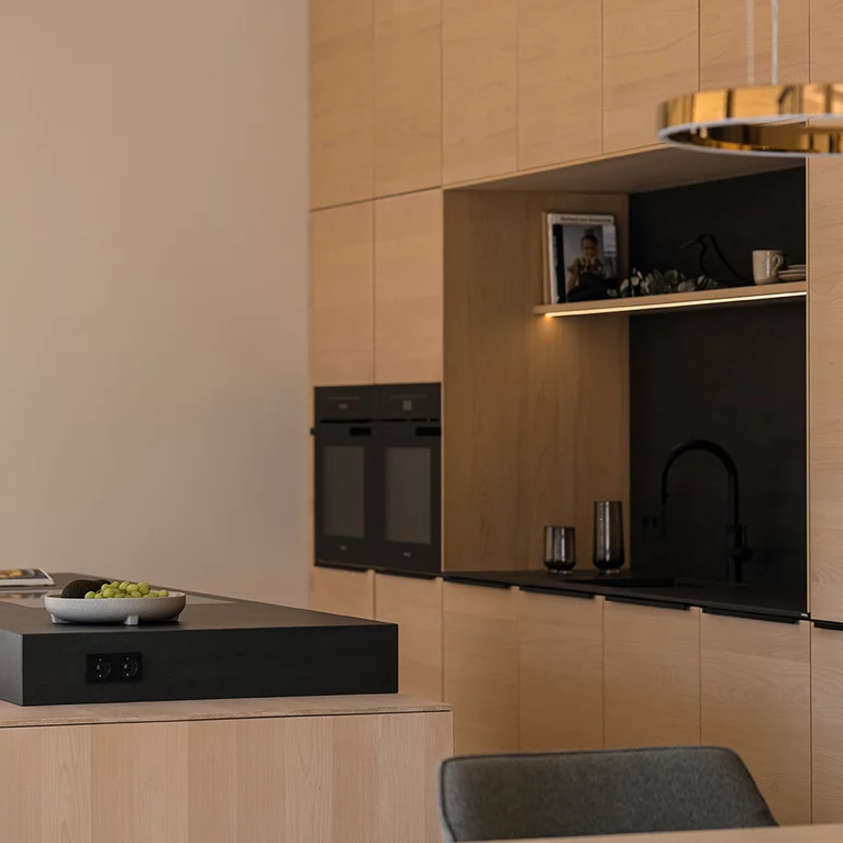 Floor-to-ceiling kitchen units with generous, integrated work recess in natural stone