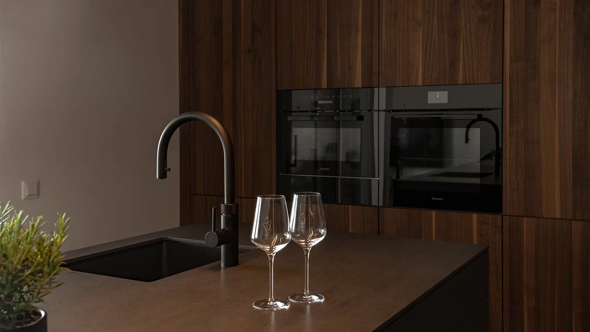 Elegante Kombination aus massivem Nussbaumholz, dunkler Keramik und schwarzen Küchengeräten Elegante Kombination aus massivem Nussbaumholz, dunkler Keramik und schwarzen Küchengeräten