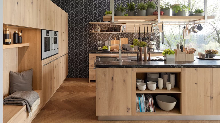 modern loft kitchen in wild oak white oil with seating niche and cooking island with a worktop made of marbled natural stone