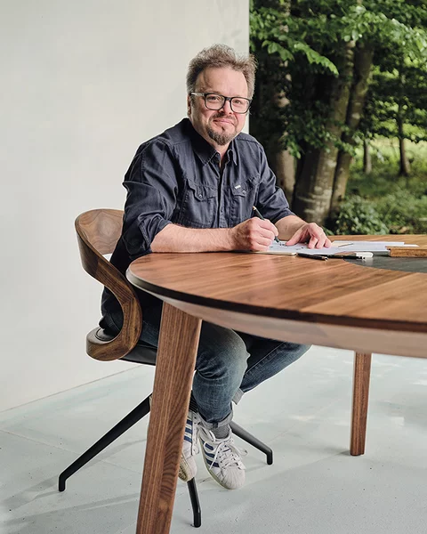 Designer Sebastian Desch with the self-designed miró dining table in walnut