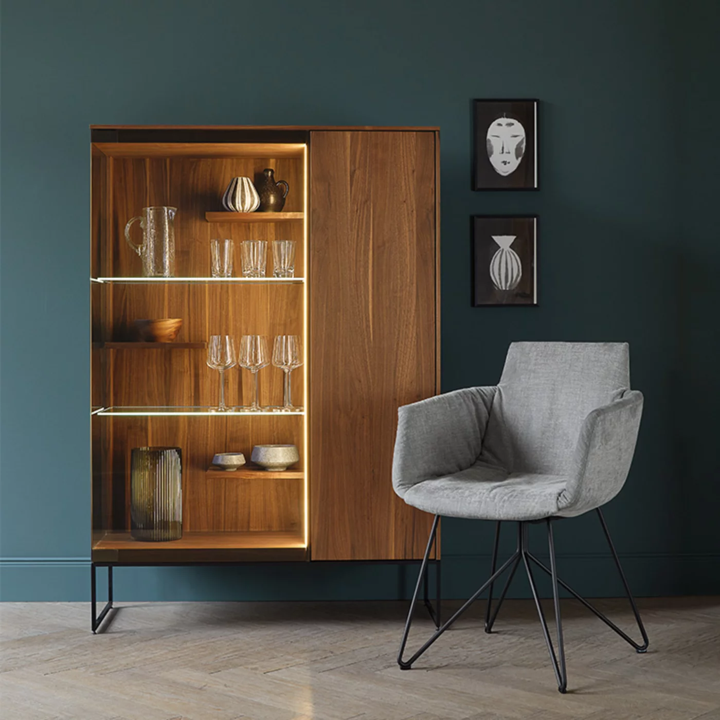 filigno wooden display cabinet in walnut with smoked glass door and metal frame in matt black and the comfortable grand lui chair