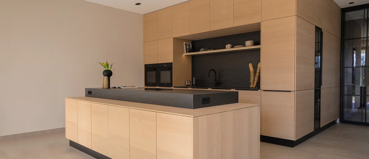 filigno kitchen in solid beech white oil with dark natural stone niche and raised natural stone block