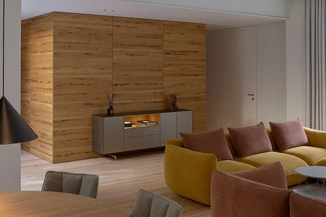 cubus pure Sideboard mit Farbglas-Ummantelung auf Metallkufen und beleuchteter Nische aus Eiche vor maßgefertigtem Schrank in Eiche Venedig