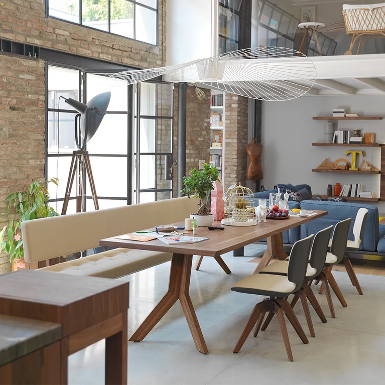 modern yps extendable dining table in solid walnut with the aye swivel base chair and the yps upholstered bench with backrest