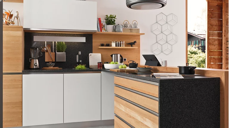 natural wood kitchen l1 in alder with coloured glass fronts in matt white with handle strips in stainless steel finish and bar element