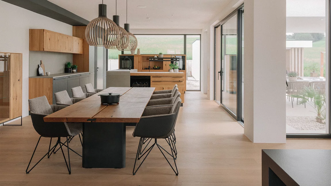 echt.zeit kitchen behind echt.zeit solid oak table with grand lui chairs with leather and fabric cover