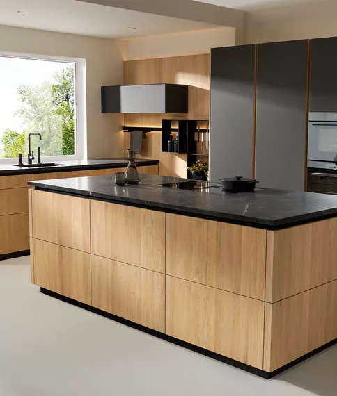 grifflose Massivholzküche pur mit Farbglas graphitgrau matt und Naturstein infinity brown