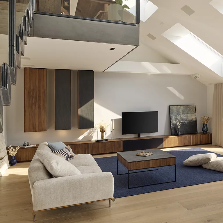 offenes Wohnzimmer mit filigno Wohnwand und filigno step Couchtisch aus Nussbaum und Keramik