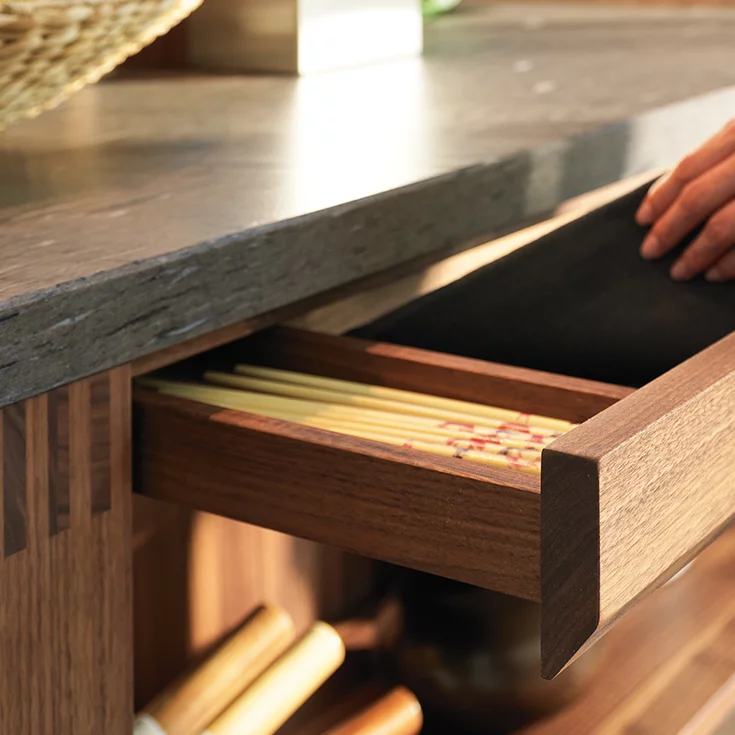 loft kitchen in wild walnut with drawer and worktop in natural stone in the colour brown silk, detailed view