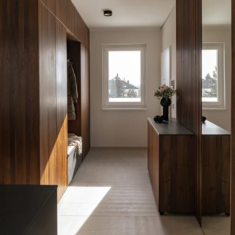 Maßgefertigte Garderobe aus Massivholz und Keramik für die perfekte Raumnutzung Maßgefertigte Garderobe aus massivem Nussbaumholz und dunkler Keramik für die perfekte Raumnutzung