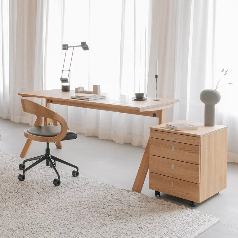 home office consisting of mobile pedestal with desk and office swivel chair next to sliding shelf in solid wood home office consisting of cubus desk container with atelier desk and girado office swivel chair next to cubus sliding shelf in oak white oil