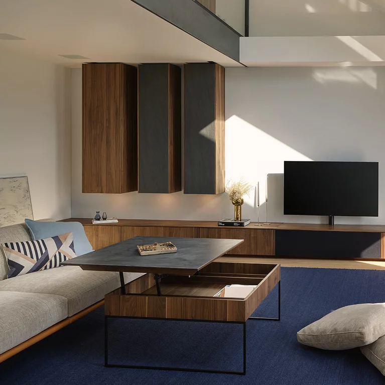 filigno step coffee table with black metal frame combined with the filigno wall unit in walnut wood and basalt black ceramic