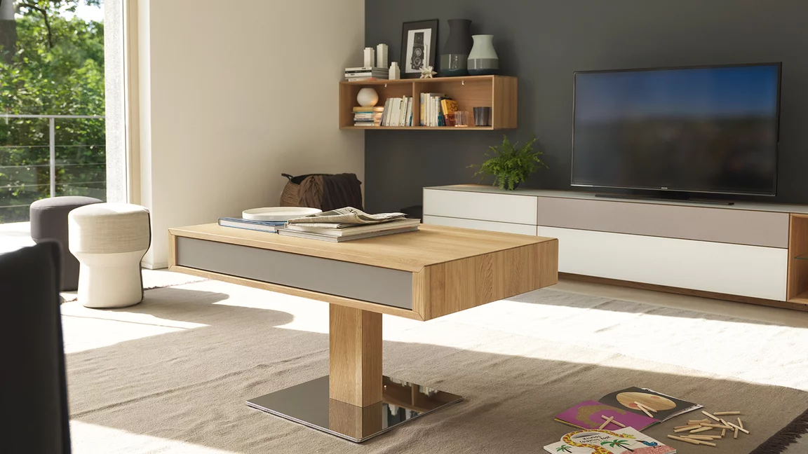 eleganter Couchtisch im Wohnzimmer neben cubus pure Wohnwand in Eiche und Farbglas